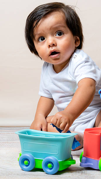 istock Curious baby boy playing with toy train 2241066306