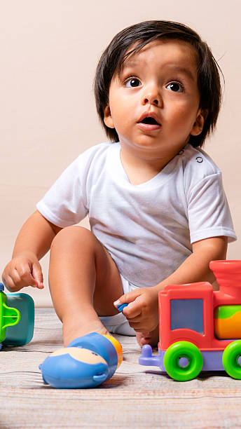 istock Baby boy playing with toy train looking up surprised 2241066963