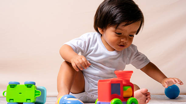 istock Baby boy playing with colorful toy train 2241067007