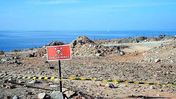 A warning sign about falling rocks next to a coastal cliff in Narrabeen, Australia