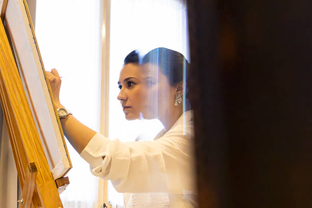 watching a woman work on her painting through the mirror