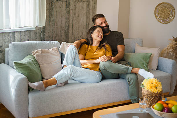 istock Happy couple relaxing on sofa at home 2241068577