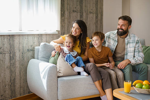 istock Happy family relaxing on couch watching TV 2241068833