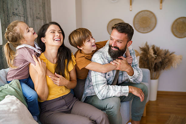 istock Happy family laughing together while relaxing at home 2241068928
