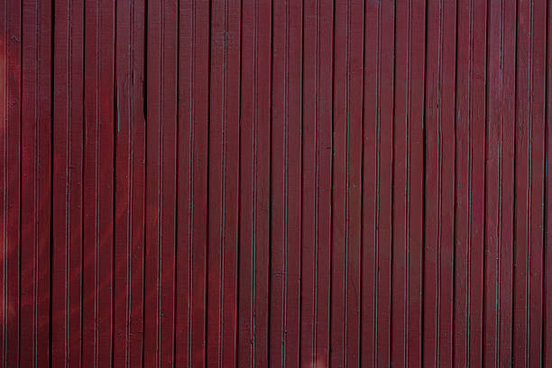 Dark red wooden wall with vertical planks, subtle natural texture, showcasing weathered wood surface in moody trendy color of year. Concept of wood texture, rustic background, vintage atmosphere
