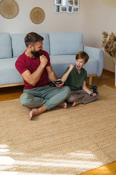 istock Father and son playing video games celebrating winning 2241069184