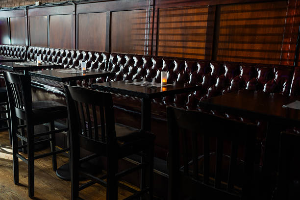 istock Empty bar interior with dark wood and leather booths 2241071489