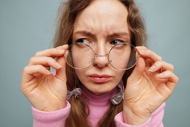 istock Woman adjusting round glasses closeup vision check and skeptical expression 2241071876