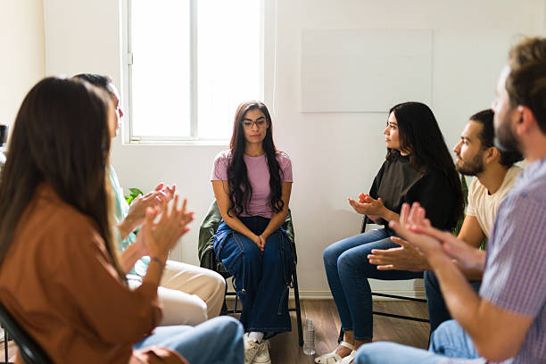 istock Young woman receiving support in group therapy session 2241075215