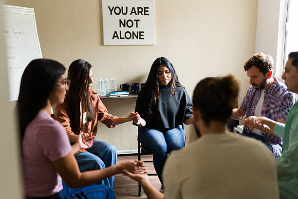 istock Hopeful group of people joining hands in support group 2241076028