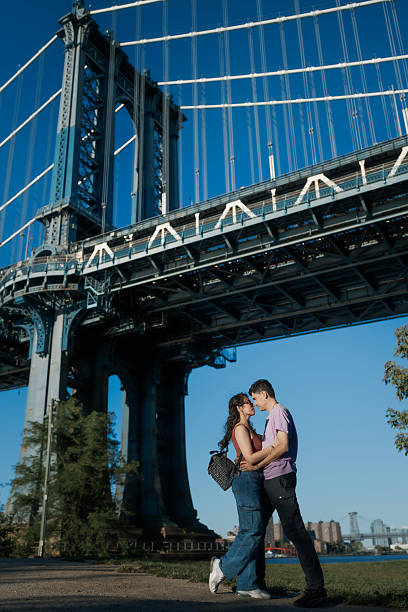 istock Young couple hugging under manhattan bridge 2241076590