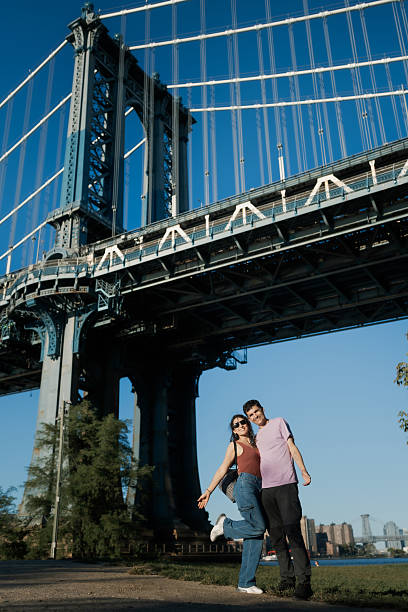 istock Couple visiting new york city under manhattan bridge 2241076607