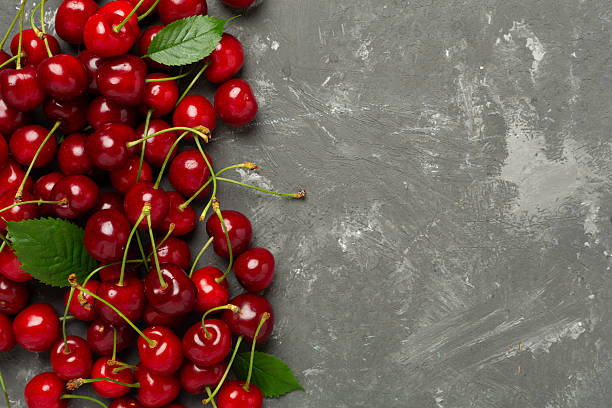 istock Fresh cherries in bowl on concrete background, top view 2241076866