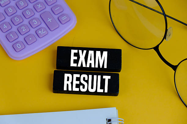 istock EXAM RESULT on white pad with exam tools on yellow background 2241084632