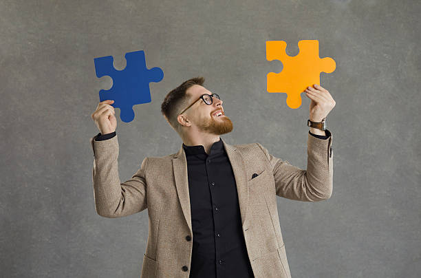 istock Man connecting pieces of jigsaw puzzle as metaphor for professional business solution 2241088792