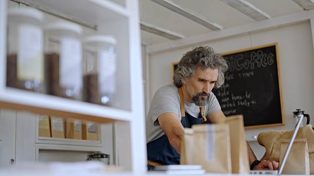 istock Eco-Friendly Coffee Shop. Focused Artisan At Work With Laptop 2241089747