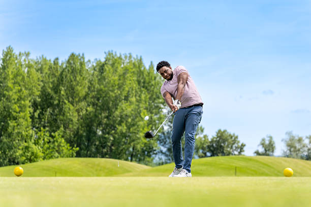 istock African American Golfer in Mid-swing on Lush Course 2241090047