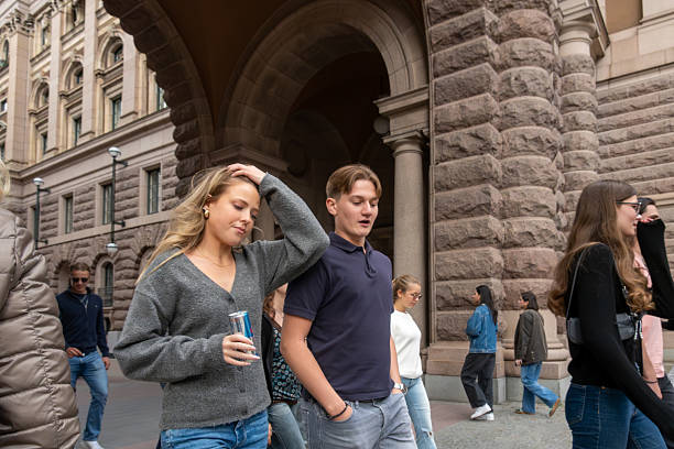 Stockholm, Sweden Aug 21, 2025 A young man and woman walking near the Swedish Parliament.