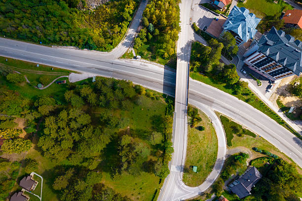 Roads intersecting with a bridge overpass, surrounded by green nature and buildings