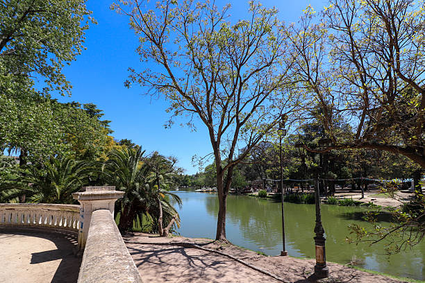 Ornate balustrade and park path overlooking Paseo del Bosque lake in La Plata, Argentina. Famous for rowboat and pedal boat rentals for leisure.