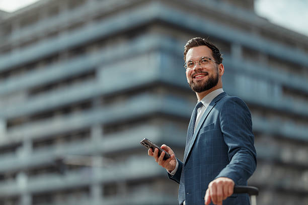 istock Smiling Businessman Using Smartphone Outdoors 2241096111