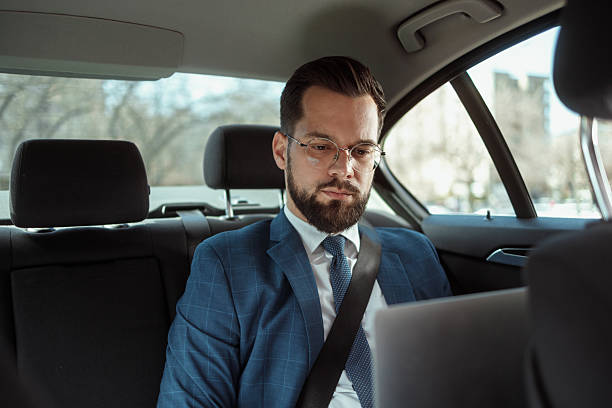 Businessman Working on Laptop in Car