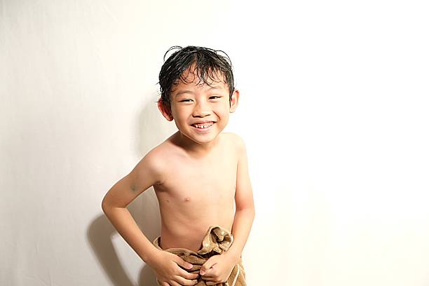 Cute little toddler having shower in bathtub