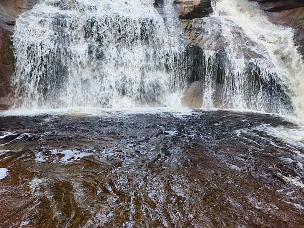 istock The Majestic Waterfall Cascading Gracefully Over the Rugged Rocky Terrain below it 2241103658