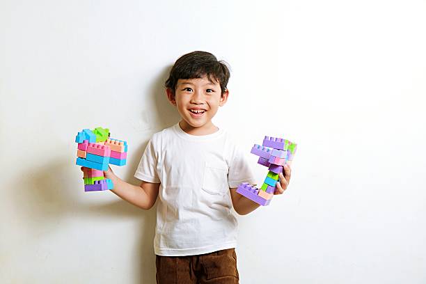 Enthusiastic boy holding his plastic building block airplane with bright smile, representing creativity and learning through playtime.