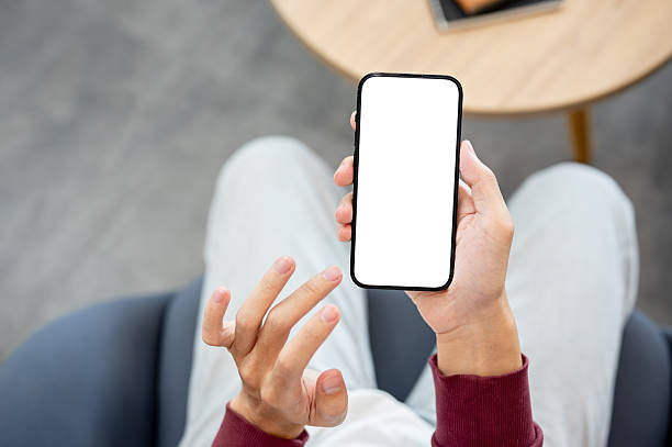 istock A hand holding white screen smartphone with fingers hovering over while sitting in a cafe or library 2241105831