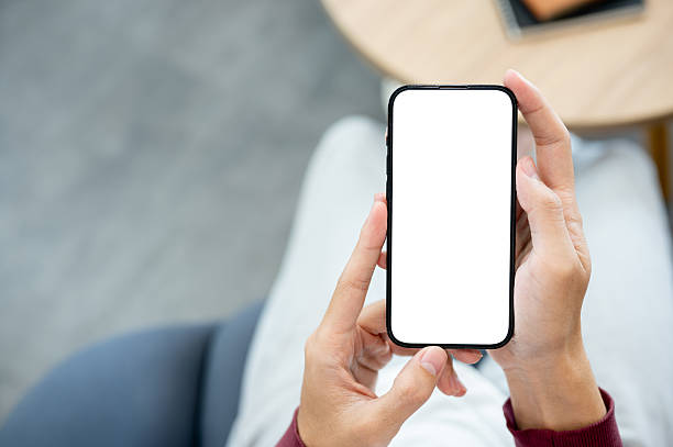 istock A pair of hands holding white screen smartphone in both hand while sitting indoor at cafe or library 2241105836