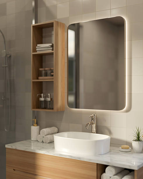istock Rectangle mirror and wooden float shelf on tile wall over marble sink counter with towel in bathroom 2241110385