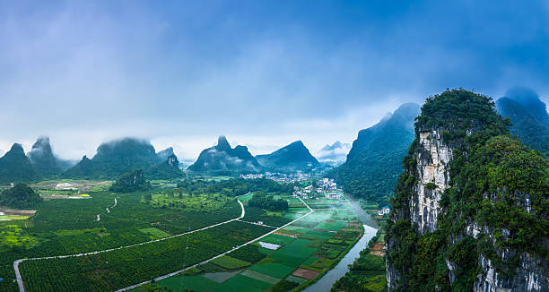 istock A river winding through a green valley with karst mountains shrouded in mist on a cloudy day. 2241114674