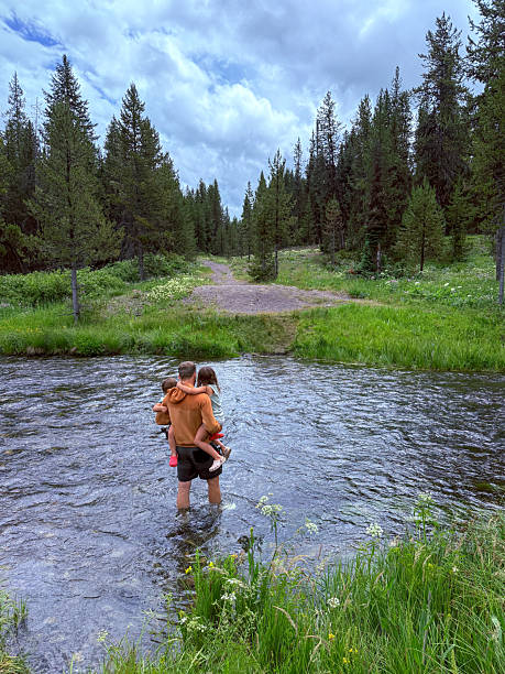 istock Man wading in river with his kids 2241116475