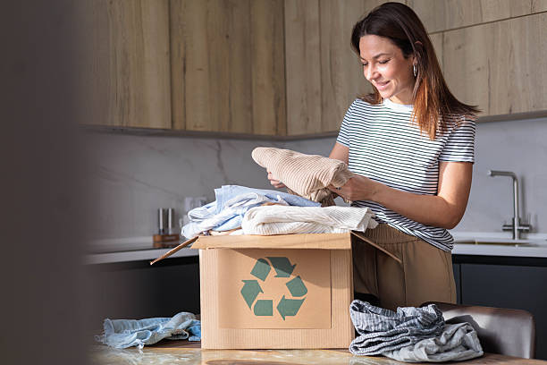 istock Woman sorting clothes in kitchen for textile recycling and donation in eco-friendly box 2241118465