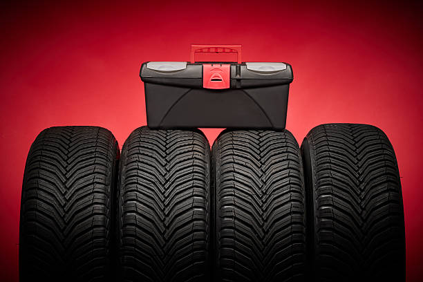 istock Car tires, new tyres, winter wheels, toolbox with instruments on red background 2241126770