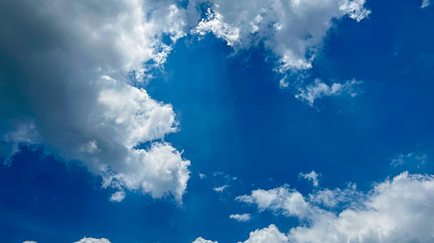 Beautiful blue sky with white clouds on a bright sunny day. Natural atmosferis background perfect for weather themes, relaxation concepts, or environmental designs.