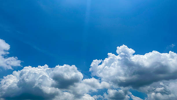 Beautiful blue sky with white clouds on a bright sunny day. Natural atmosferis background perfect for weather themes, relaxation concepts, or environmental designs.