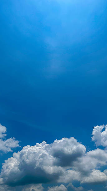 Beautiful blue sky with white clouds on a bright sunny day. Natural atmosferis background perfect for weather themes, relaxation concepts, or environmental designs.