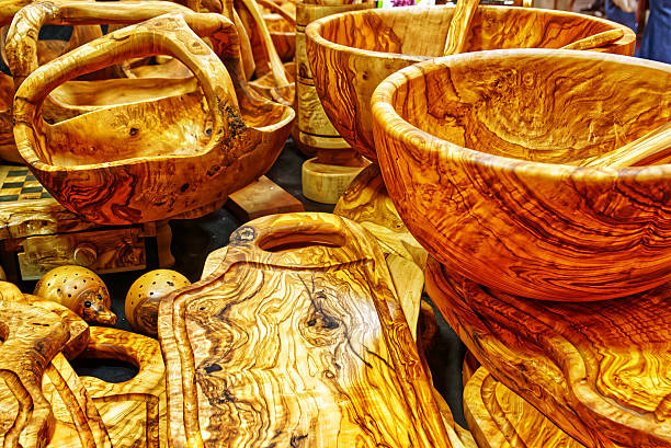 Collection of natural olive wood kitchenware with unique grain patterns, including bowls, serving dishes, and cutting boards
