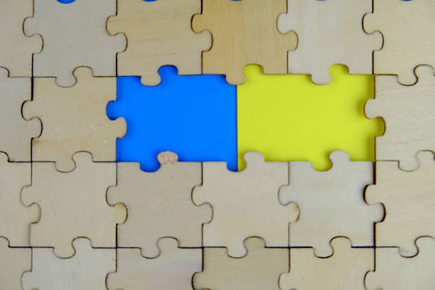istock white jigsaw puzzle with missing puzzle for a text template. Above photo of isolated on the brown and green background 2241127697