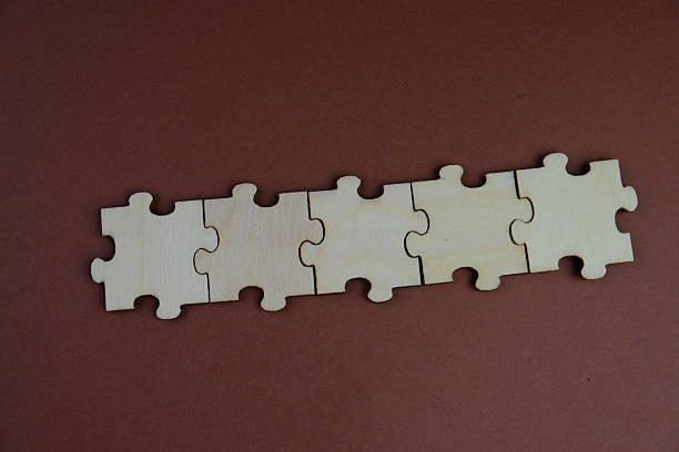 istock white jigsaw puzzle with missing puzzle for a text template. Above photo of isolated on the brown and green background 2241127713