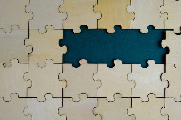 istock white jigsaw puzzle with missing puzzle for a text template. Above photo of isolated on the brown and green background 2241127745