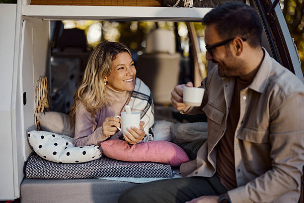istock Happy couple talking while relaxing in camper trailer. 2241128626