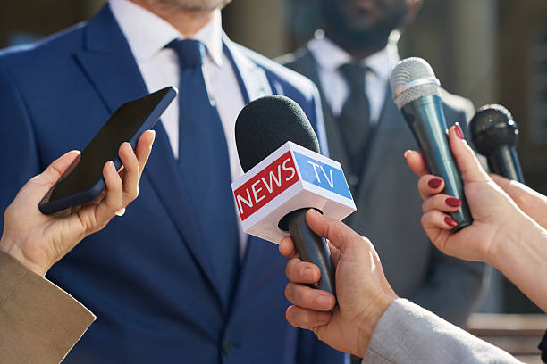 istock Caucasian Middle Aged Man Giving Interview Surrounded by Journalists Holding Microphones 2241129918
