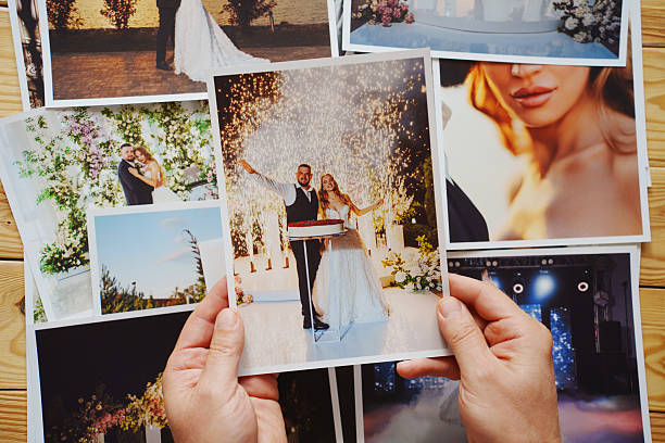 istock Men's hands put on the table and show wedding photos. 2241132002