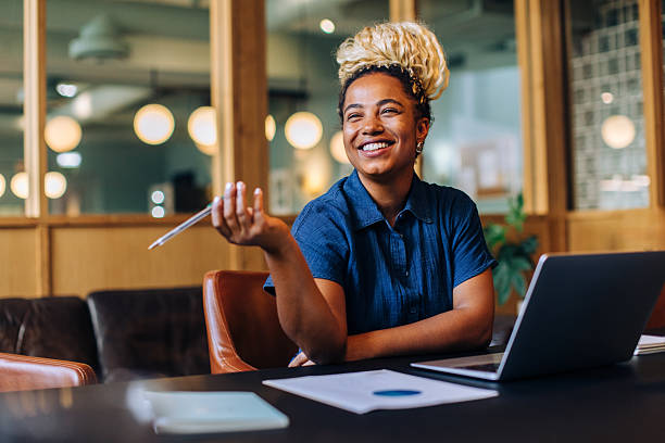 istock Smiling young woman holding pen while working in an office environment 2241134887