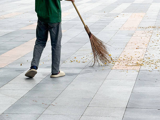 istock A municipal worker sweeps dry leaves from a tiled walkway in a public park. The image symbolizes cleanliness, discipline, and care for public spaces in urban environments. 2241135421