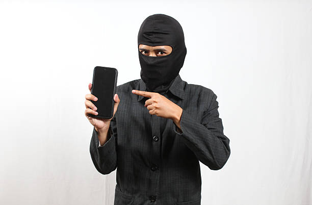 istock Thief Demonstrating Modern Smartphone Gadget Representing Criminal Activity and Internet Scam 2241136007
