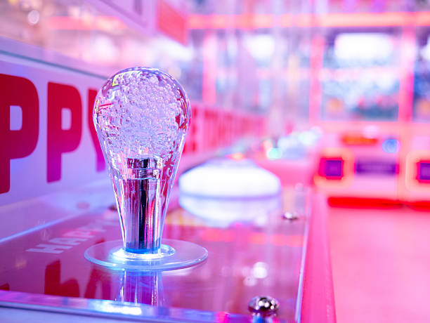 istock Transparent Light Bulb Shaped Joystick Controller on Pink Arcade Game Machine in Retro Entertainment Center 2241137759